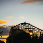 a roller coaster at sunset with the sky in the background