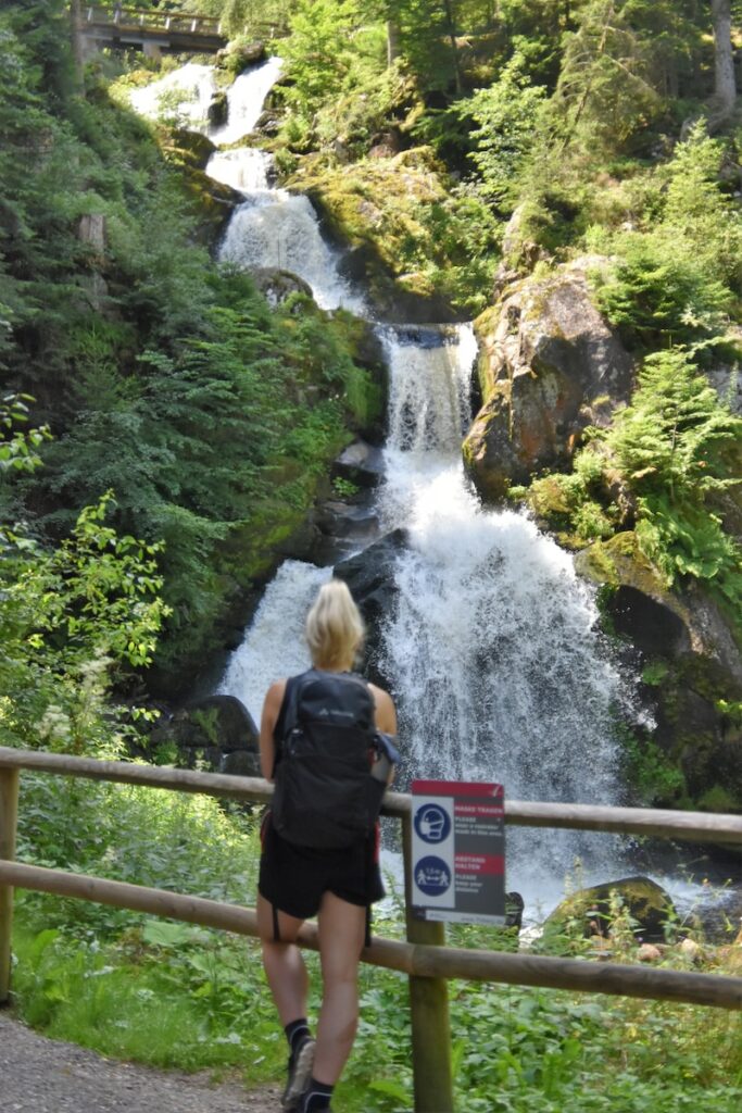 a person standing next to a waterfall